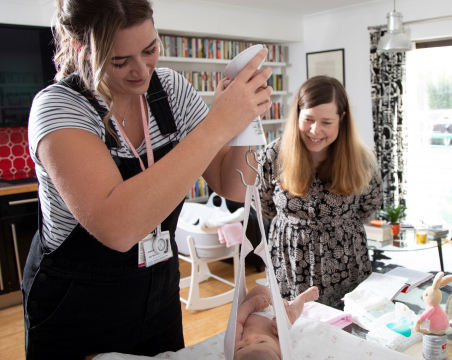 midwife weighing baby