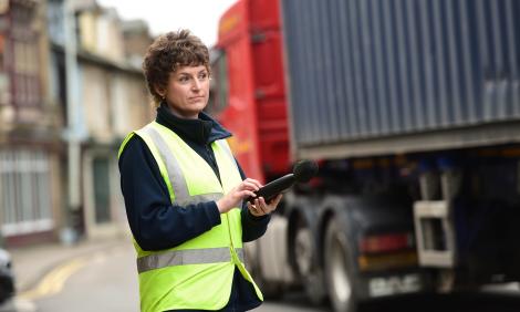 Environmental health professional measuring traffic noise Environmental health professional measuring traffic noise