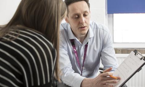 Male support worker talking to female client