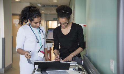 Two female doctors consulting notes