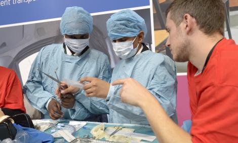 Boys in scrubs looking at surgical instruments
