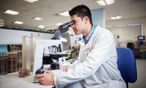 Healthcare scientist with microscope Healthcare scientist with microscope