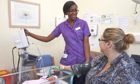 midwife with patient and baby on ward Midwife with baby on ward