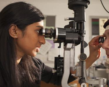 Female ophthalmologist checking eye