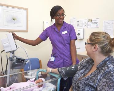 Midwife with baby on ward