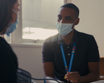 nurse with mask talking to patient