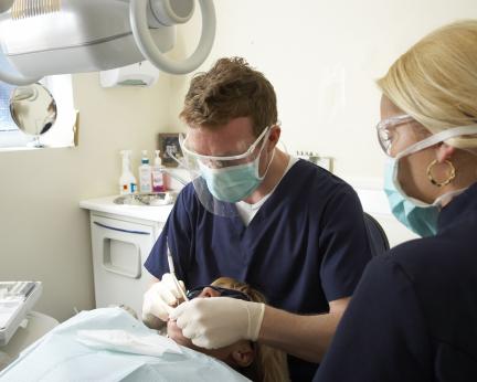 dental-male-and-female-colleague-treating-patient's-teeth dental-male-and-female-colleague-treating-patient's-teeth