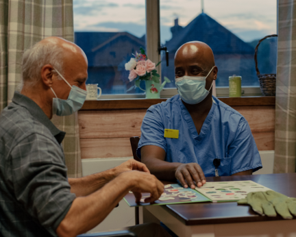 healthcare support worker sitting at table with patient