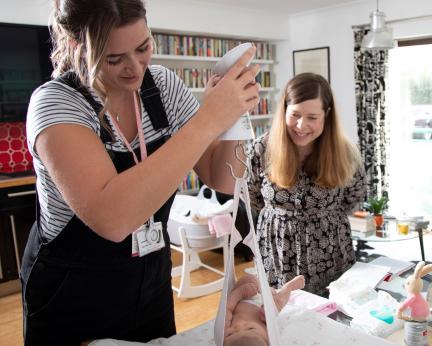 midwife weighing baby