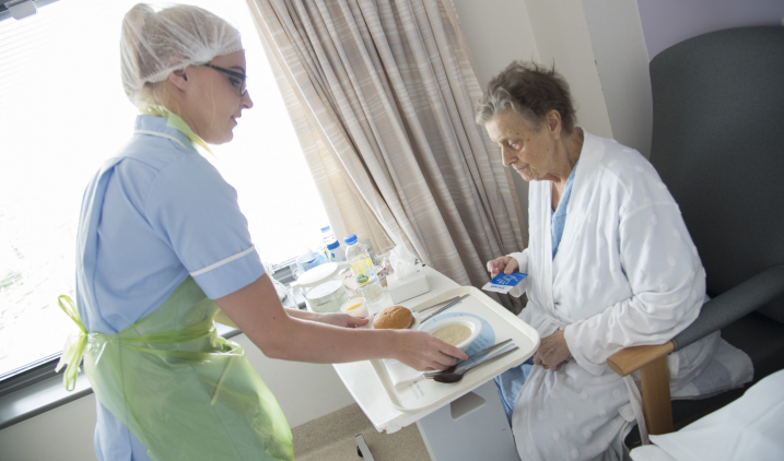 Healthcare assistant serving lunch to patient Healthcare assistant serving lunch to patient