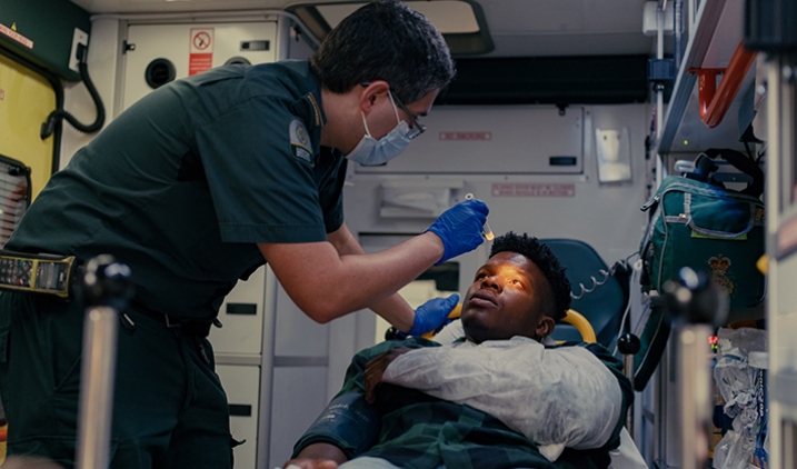 paramedic shining light in patient's eys in an ambulance