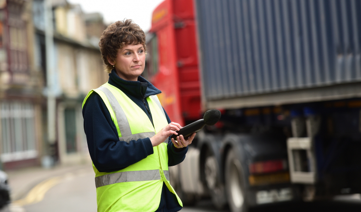 Environmental health professional measuring traffic noise Environmental health professional measuring traffic noise