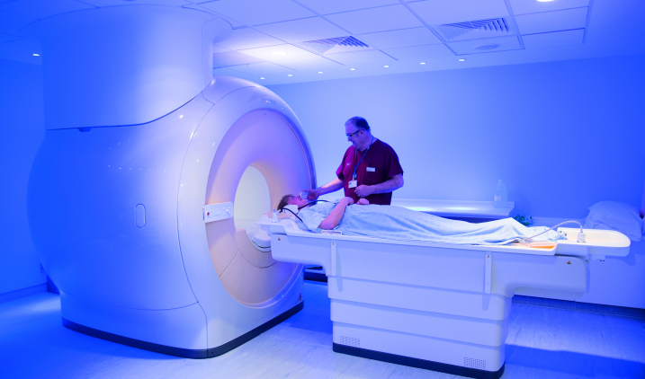 Staff member with patient going in scanner Staff member with patient going in scanner