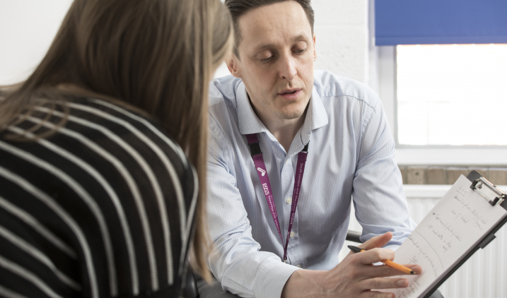 Male support worker talking to female client Male support worker talking to female client