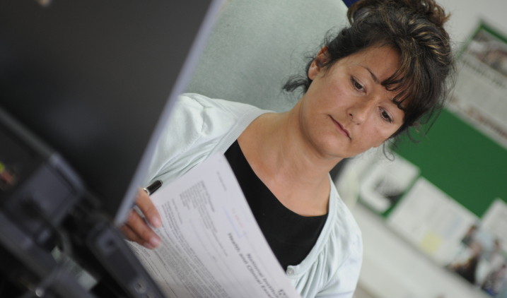 Female member of staff checking paperwork Female member of staff checking paperwork