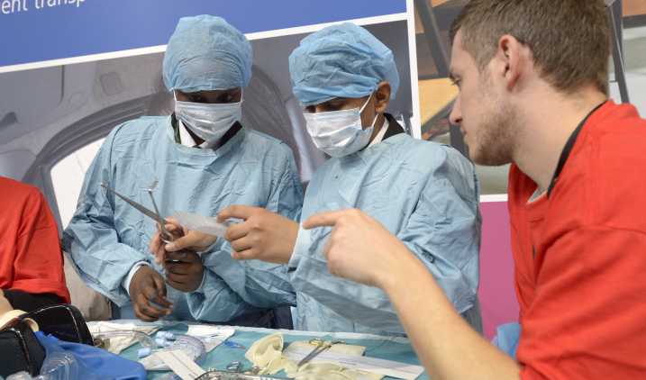 Boys in scrubs looking at surgical instruments Boys in scrubs looking at surgical instruments