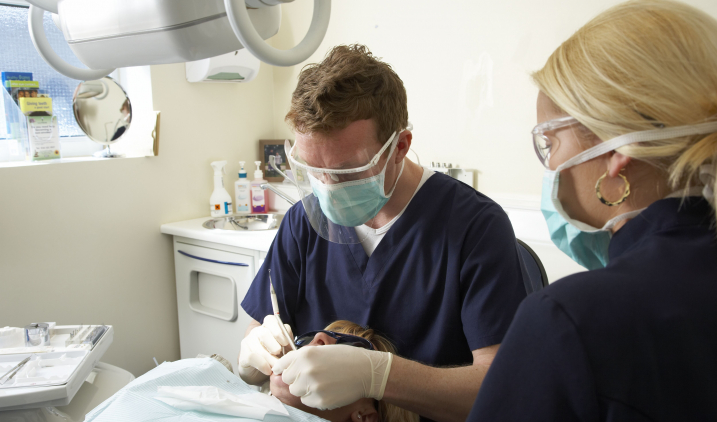dental-male-and-female-colleague-treating-patient's-teeth dental-male-and-female-colleague-treating-patient's-teeth