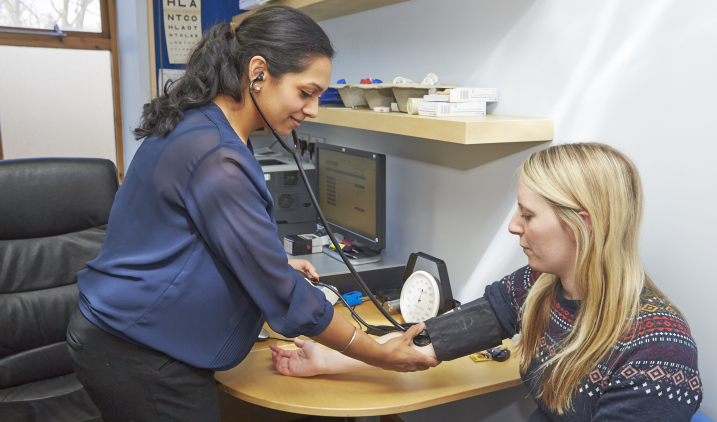 Female GP taking blood pressure Female GP taking blood pressure