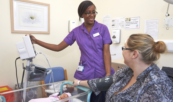 Midwife with baby on ward Midwife with baby on ward