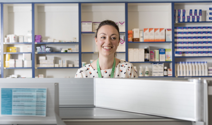 pharmacist smiling from behind counter