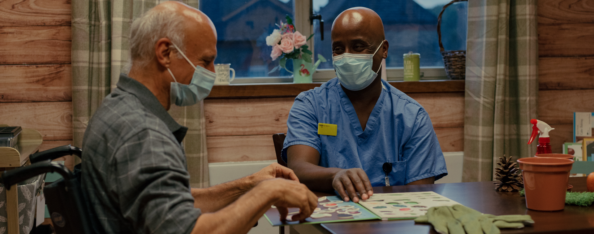 healthcare support worker sitting at a table with patient